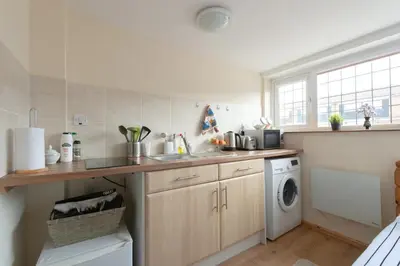 a kitchen with a sink and a washing machine at Simple Private Studio in Harold Wood