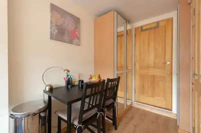 a room with a black table and chairs and a door at Simple Private Studio in Harold Wood