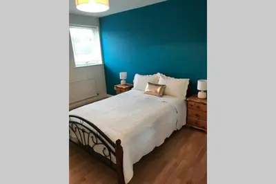 a bedroom with a large bed with a blue wall at A Home Away from Home in Ipswich