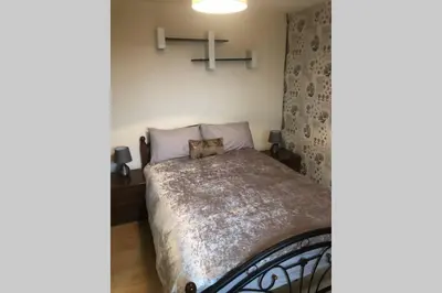 a bedroom with a bed with a cat sitting on it at A Home Away from Home in Ipswich