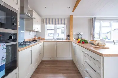 a kitchen with white cabinets and a counter top at Hunky-Dory - Aldeburgh Coastal Cottages in Sizewell