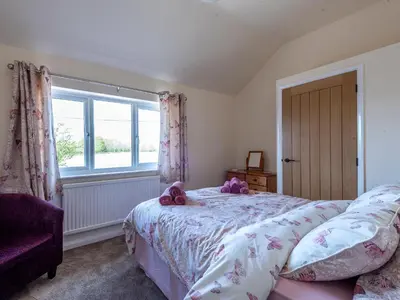 a bedroom with a bed with purple stuffed animals on it at Old Alton Hall Farmhouse in Tattingstone