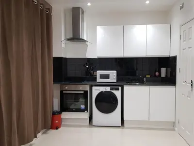 a kitchen with a washing machine and a microwave at Orwell Suite in Ipswich