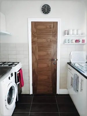 a kitchen with a washer and a wooden door at Richmond Luxury flat Fabulous location in Southend-on-Sea