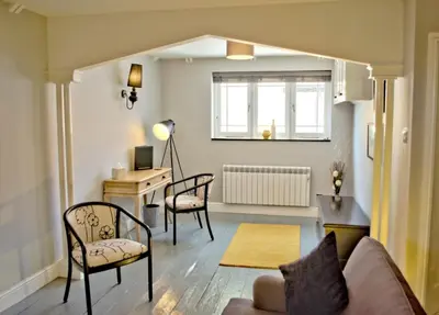 a living room with a couch and chairs and a desk at City Studios in Ely