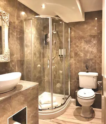 a bathroom with a shower and a toilet and a sink at City Studios in Ely