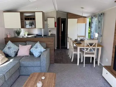 a living room and kitchen with a couch and a table at Kellys Holiday Homes 24 Willerby 2 bedrooms caravan in Weeley