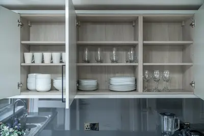 a kitchen cabinet filled with glasses and plates and dishes at Skyvillion-STEVENAGE Amazing 3Bed House, Garden, Free Off Street Parking for 2 Cars, WiFi in Stevenage