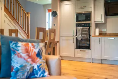 a living room with a couch and a kitchen at Garden Villa in Cambridge
