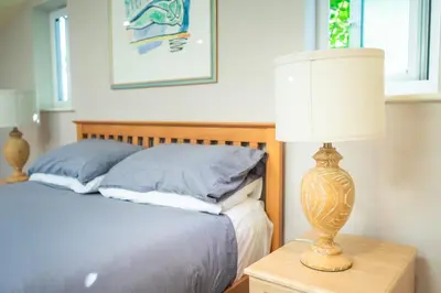 a bedroom with a bed and a table with a lamp at Garden Villa in Cambridge