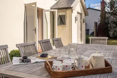 a picnic table with a tray of cups and mugs at Alexander House 4 in Thorpeness