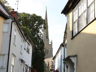 an empty street with a church in the background at Flink's Barn in Great Dunmow