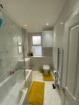 a white bathroom with a tub and a toilet at Breeze on Southend in Essex in Southend-on-Sea