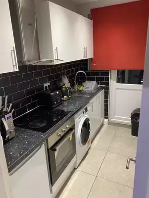 a kitchen with a stove and a washing machine at Breeze on Southend in Essex in Southend-on-Sea