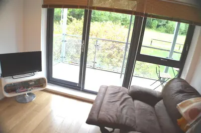 a living room with a couch and a large window at 360 Serviced Accommodations - Brentwood 2 Bedroom Executive Apartment with Secure Parking in Brentwood