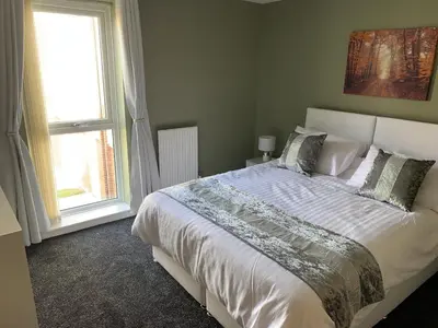 a bedroom with a large bed and a window at Toothbrush Apartments - Central Ipswich - Nr Train Station in Ipswich