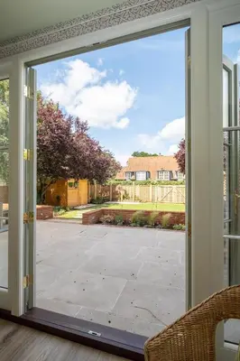 a sliding glass door with a view of a yard at 1 Westgate in Thorpeness