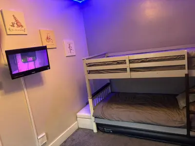 a bedroom with a bunk bed with a tv in it at Three Tuns Ashwell in Ashwell