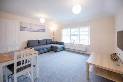 a living room with a couch and a table at 2 Abbey Mews, Leiston in Leiston