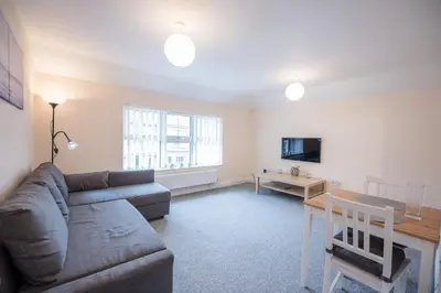 a living room with a couch and a table at 2 Abbey Mews, Leiston in Leiston