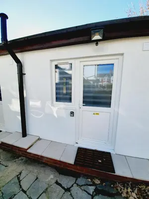 a white garage with a white door and windows at Southend on Sea - Westcliff Studios - Great Location in Southend-on-Sea