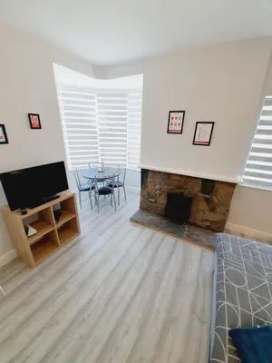 a living room with a table and a fireplace at Southend on Sea - Westcliff Studios - Great Location in Southend-on-Sea