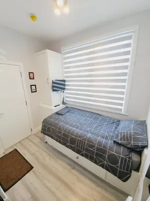 a bedroom with a bed and a large window at Southend on Sea - Westcliff Studios - Great Location in Southend-on-Sea