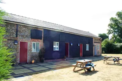 a building with two picnic tables in front of it at The White Horse in Beyton