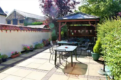 a patio with a table and a gazebo at The White Horse in Beyton