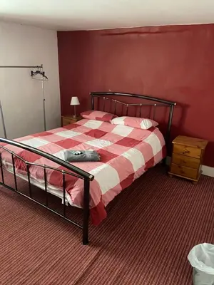a bedroom with a bed with a red wall at The Ram Inn in Brandon