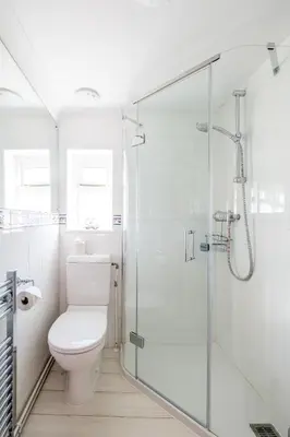 a bathroom with a toilet and a glass shower at Admiral Cottage in Aldeburgh