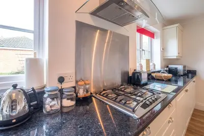 a kitchen with a stove top oven in a kitchen at April Cottage, Aldeburgh - Close to Aldeburgh beach and High Street - Managed by Aldeburgh Coastal Cottages in Aldeburgh