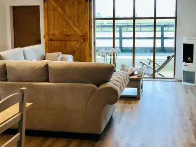 a living room with a couch and a large window at Mac Shack Cottage - Uk32376 in Ovington