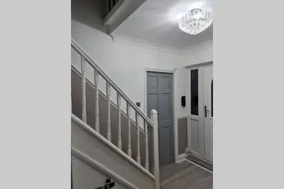 a staircase in a house with a chandelier at Berrygate in Ipswich