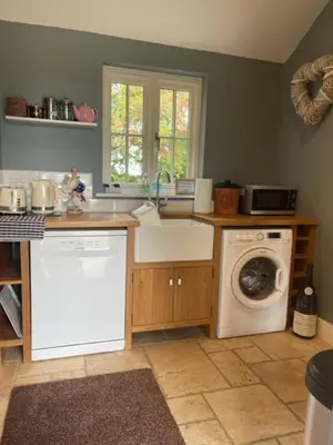 a kitchen with a sink and a washing machine at Walnut Tree Cottage Barn in Toppesfield
