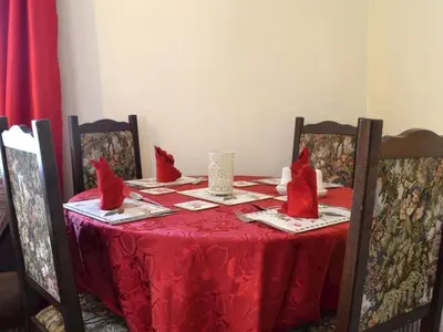 a red table with red pillows on top of it at Cottage - Sleeps 3 Parking & Fishing in Hilgay