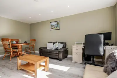 a living room with a couch and a table at Remaj Serviced Accommodation, sleeps 7 & free parking in Laindon