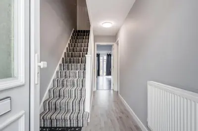 a hallway with a staircase in a house at Remaj Serviced Accommodation, sleeps 7 & free parking in Laindon