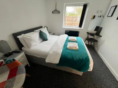 a bedroom with a bed and a desk and a window at Mayland Motel in Mayland