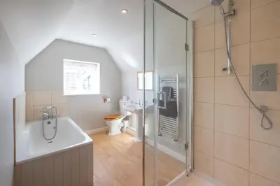 a bathroom with a shower and a tub and a toilet at 6 Lakeside Avenue in Thorpeness