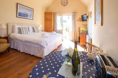 a bedroom with two beds and a table with a bottle of wine at 6 Lakeside Avenue in Thorpeness