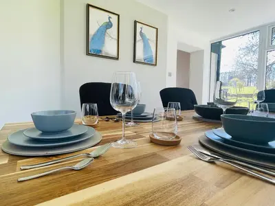 a wooden table with plates and wine glasses on it at Warren Lodge in Little Baddow