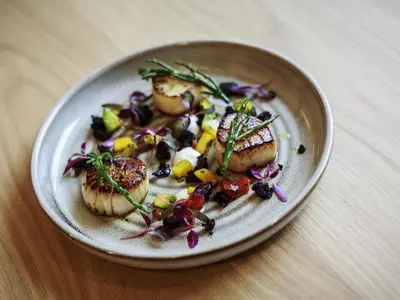 a plate of food with scallops on a table at Novotel Cambridge North in Cambridge