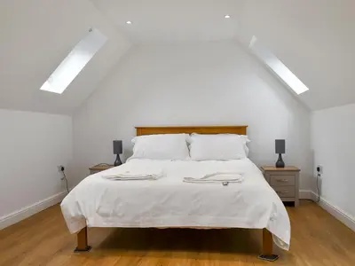 a bedroom with a white bed with two towels on it at Fallow Cottage - Uk33488 in Hadleigh