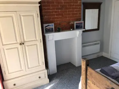 a bedroom with a bed and a white cabinet at Sea view studio in Felixstowe