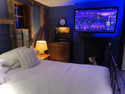 a bedroom with a bed and a flat screen tv at Alfie Acres - Secluded Cabin set in 5 Acres of Privacy, with Exclusive use of Swimming Pool and Hot Tub for up to 10 Guests in Downham