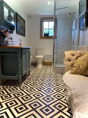 a bathroom with a shower and a couch at Alfie Acres - Secluded Cabin set in 5 Acres of Privacy, with Exclusive use of Swimming Pool and Hot Tub for up to 10 Guests in Downham