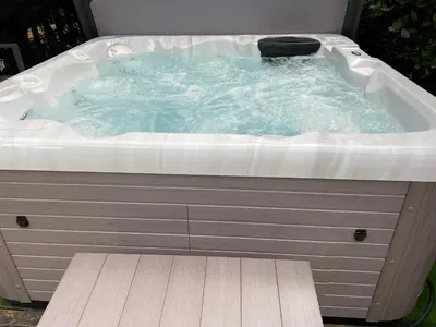 a jacuzzi tub sitting in a yard at Alfie Acres - Secluded Cabin set in 5 Acres of Privacy, with Exclusive use of Swimming Pool and Hot Tub for up to 10 Guests in Downham