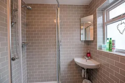 a bathroom with a sink and a glass shower at 6 West Lane in Aldeburgh - Beautiful cottage near high street in Aldeburgh
