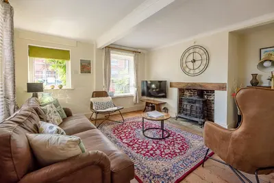 a living room with a couch and a fireplace at Abigail's Cottage, Wickham Market in Woodbridge